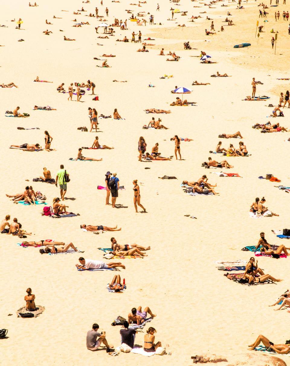 Tekst o bezpiecznym opalaniu i ochronie skóry latem. Na zdjęciu: Duża grupa ludzi na plaży - HelloZdrowie