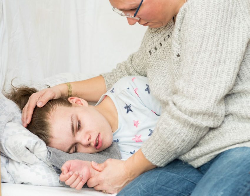 Dziewczynka leży w łóżku po tym, jak miała objawy padaczki