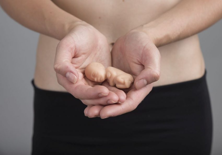 Kobieta trzyma w rękach maleńkie dziecko