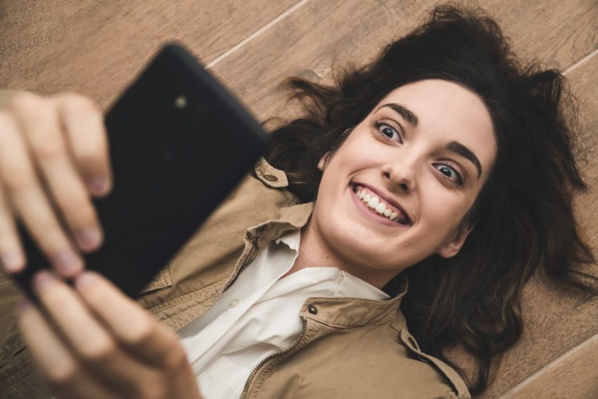 Kobieta cierpiąca na obsesję korzysta z telefonu komórkowego