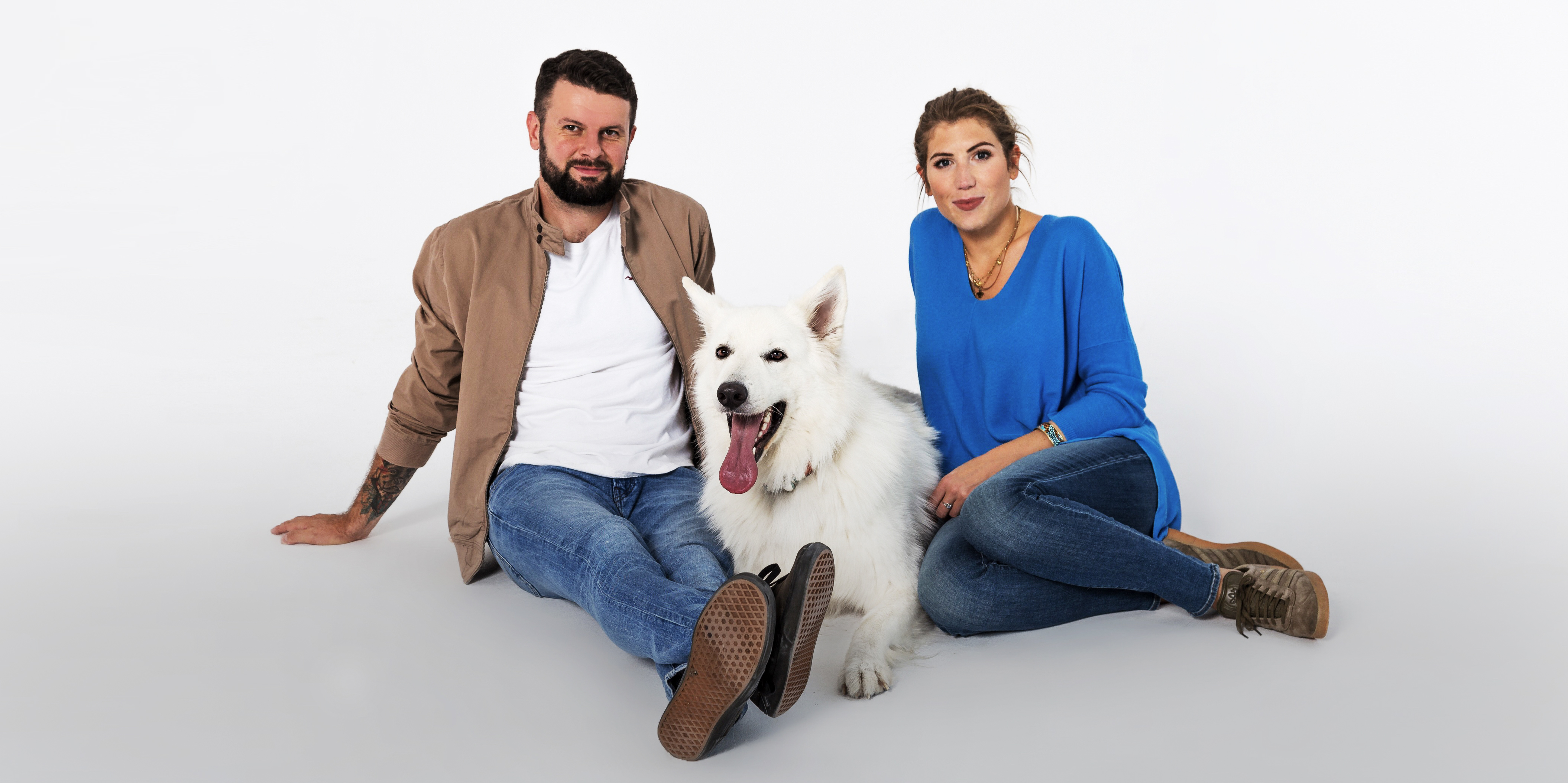 Tekst o rozumieniu psiego języka i emocji. Na zdjęciu: Mężczyzna i kobieta siedzący obok psa - HelloZdrowie