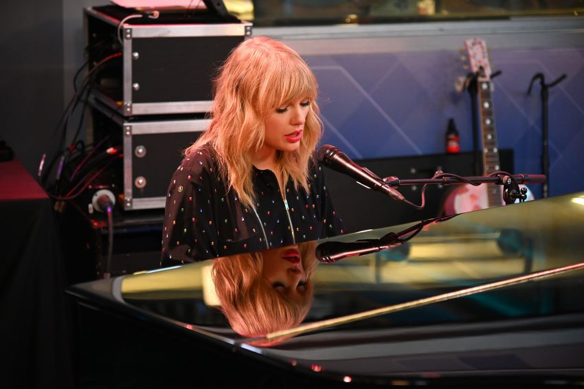 Tekst o walce Taylor Swift o niezależność i feminizm. Na zdjęciu: Kobieta siedząca za mikrofonem - HelloZdrowie