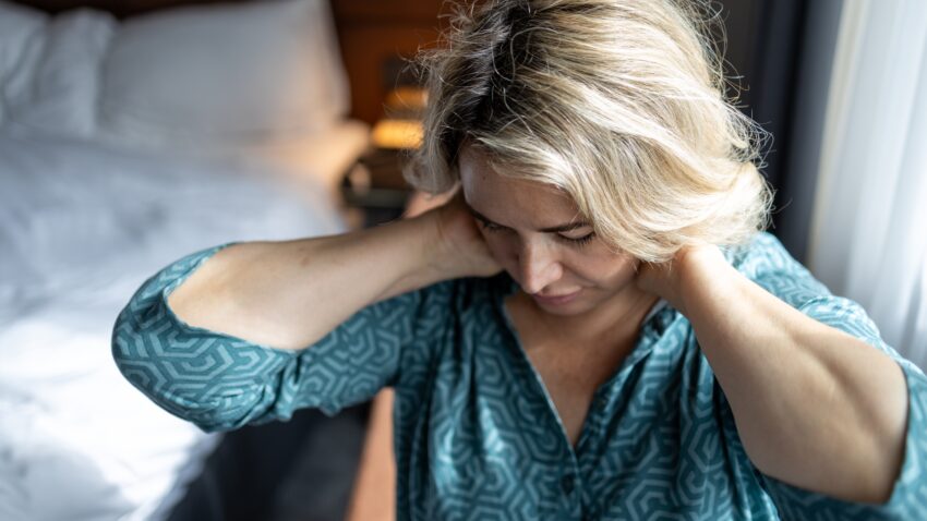 kobieta trzyma się za kark, prawdopodobnie boli ją głowa - Hello Zdrowie