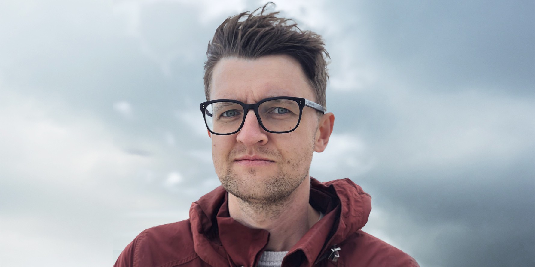 Tekst o młodych aktywistach klimatycznych i ich działaniach. Na zdjęciu: Mężczyzna noszący okulary i czerwoną kurtkę - HelloZdrowie