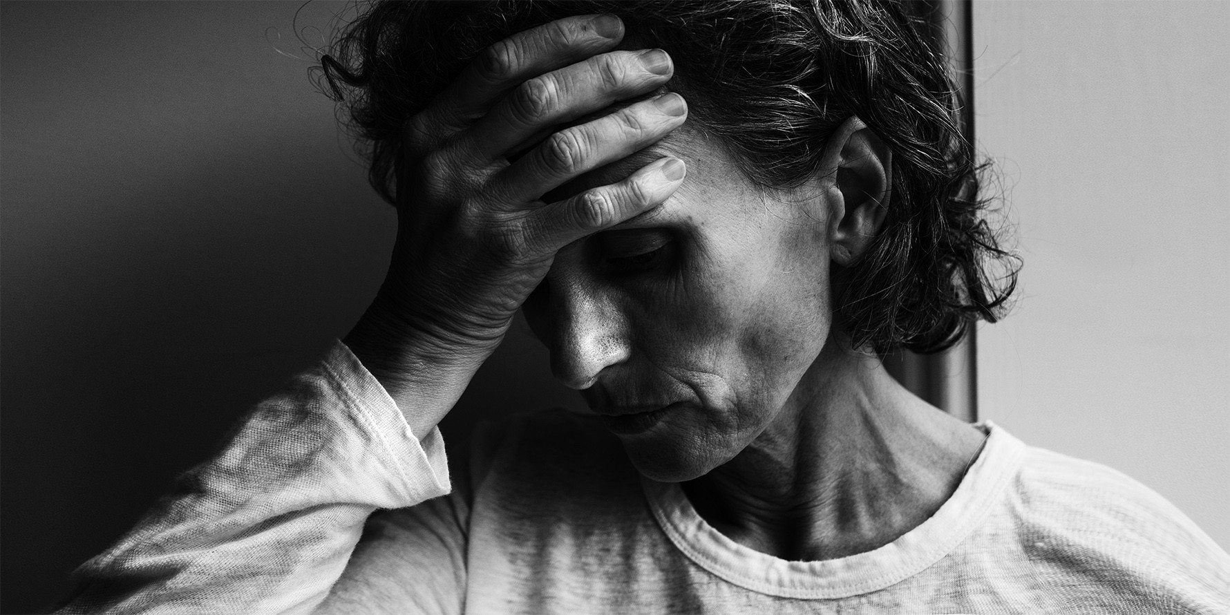 Tekst o problemie samobójstw i emocjach seniorów. Na zdjęciu: Kobieta trzymająca rękę na swoim czole - HelloZdrowie
