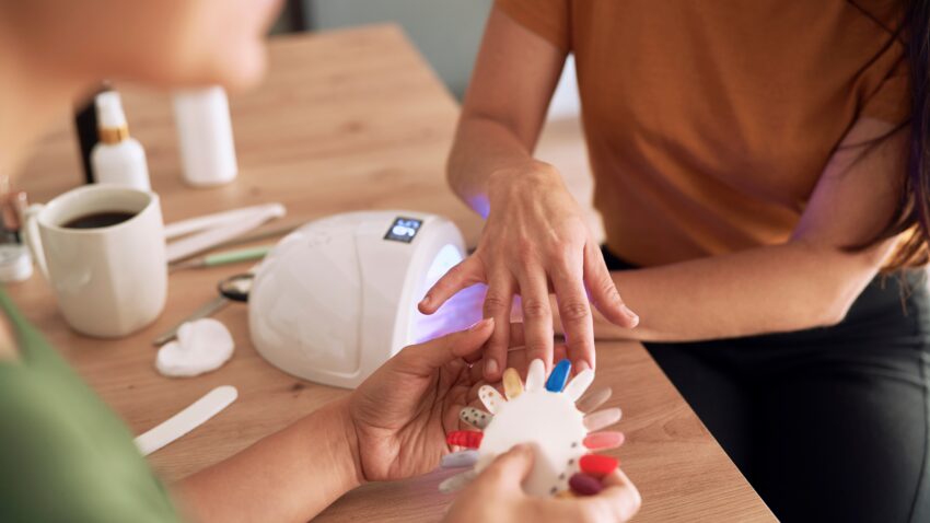 Kobieta w trakcie robienia manicure hybrydowego
