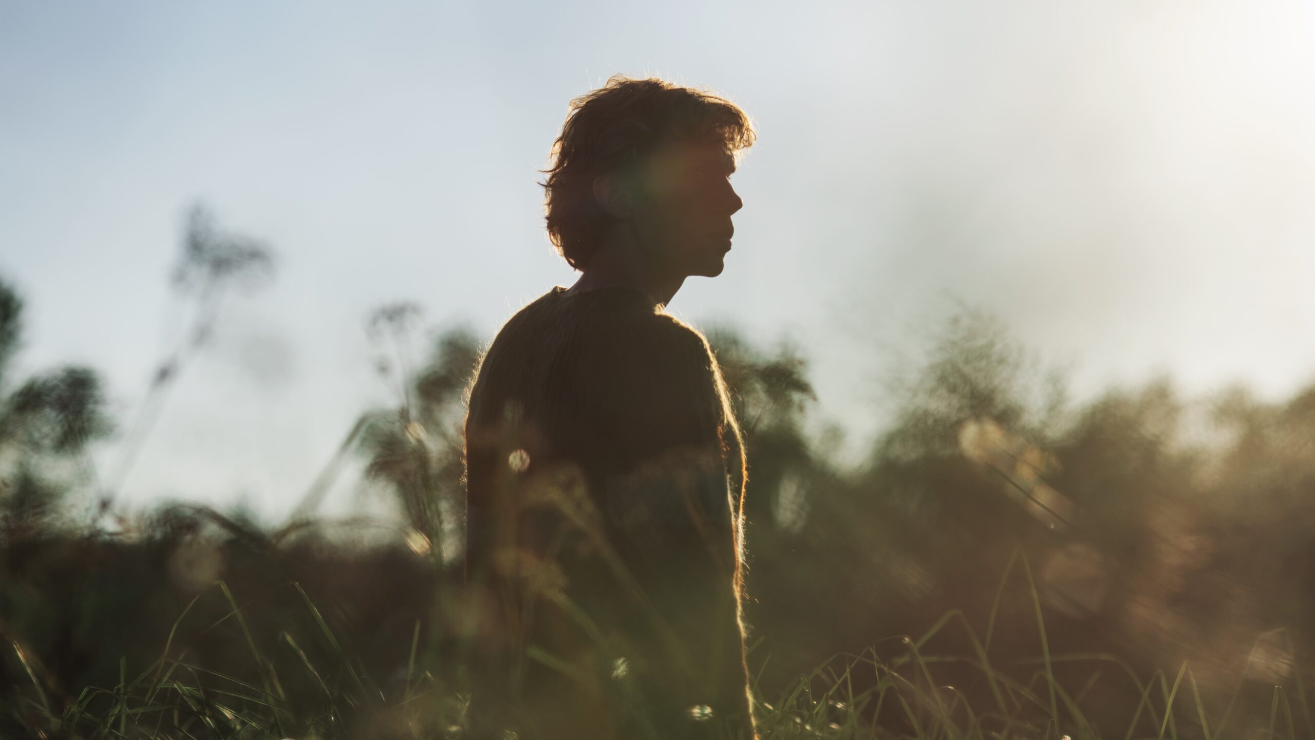 młody człowiek stoi wód wysokich traw - Hello Zdrowie