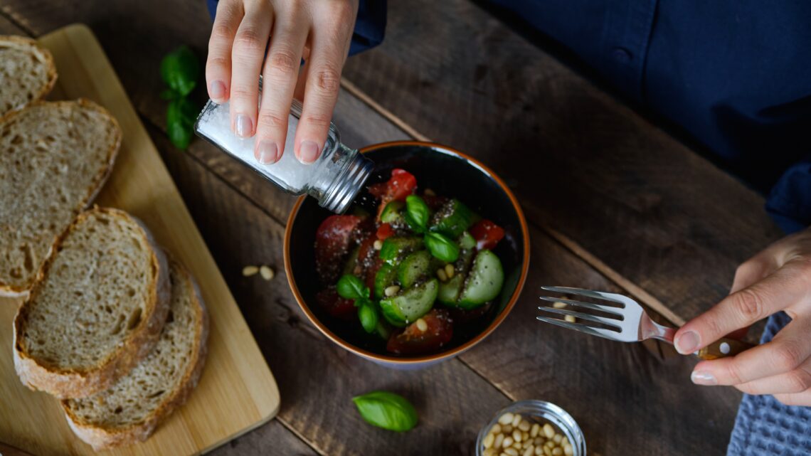 człowiek soli sałatkę z ogórków i pomidorów - Hello Zdrowie