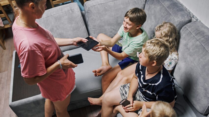 Mama rozdaje dzieciom telefony