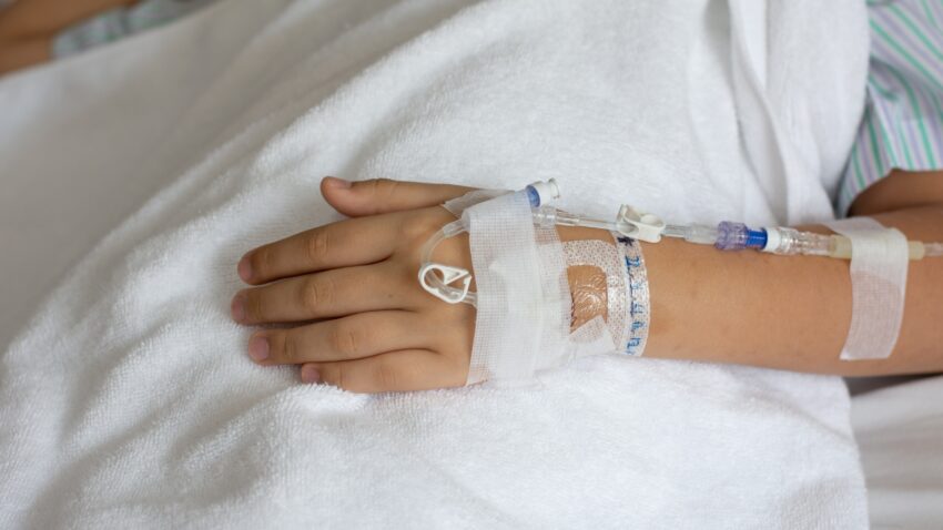 na zdjęciu: ręka dziecka leżącego w szpitalu, tekst o tym, jak lekarze z Zielonej Góry uratowali 9-latka z udarem - Hello Zdrowie