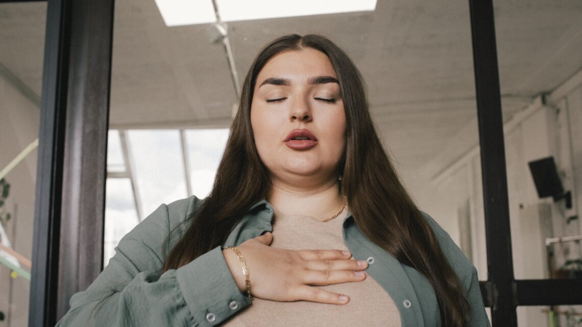 na zdjęciu: wystraszona kobieta trzyma dłoń na klatce piersiowej - Hello Zdrowie