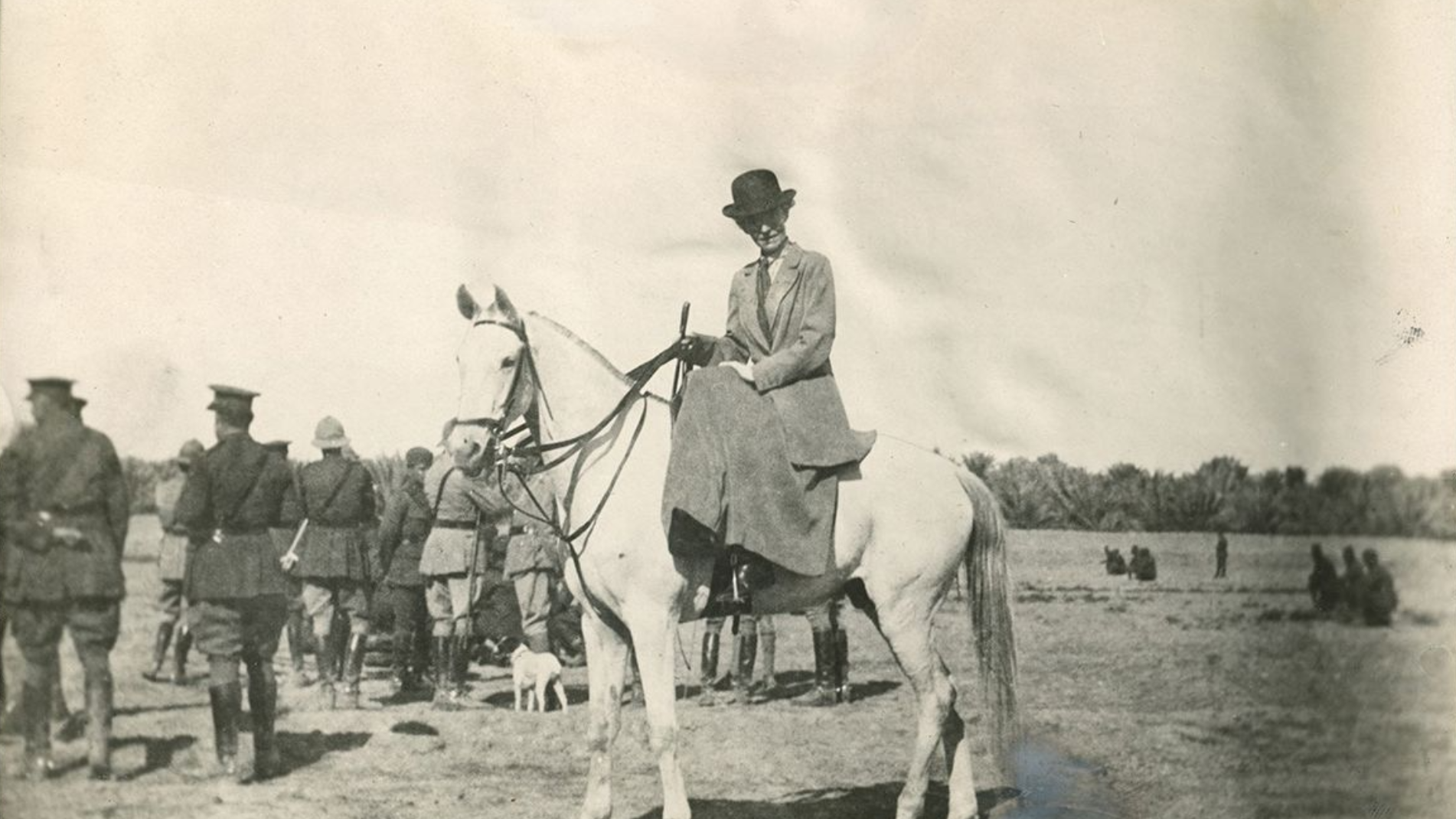 Gertrude Bell w stroju myśliwskim, na koniu. W tle oficerowie - Hello Zdrowie